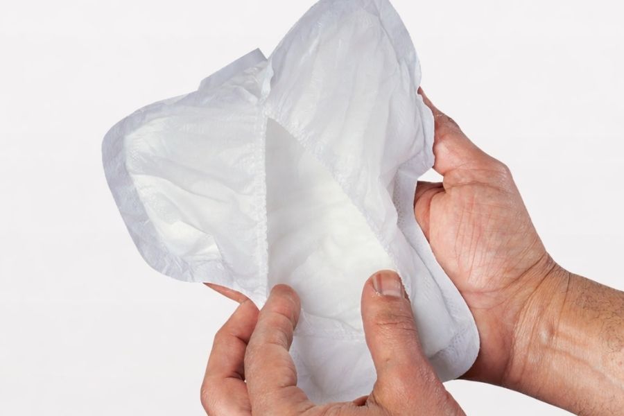 hands inspecting incontinence pad