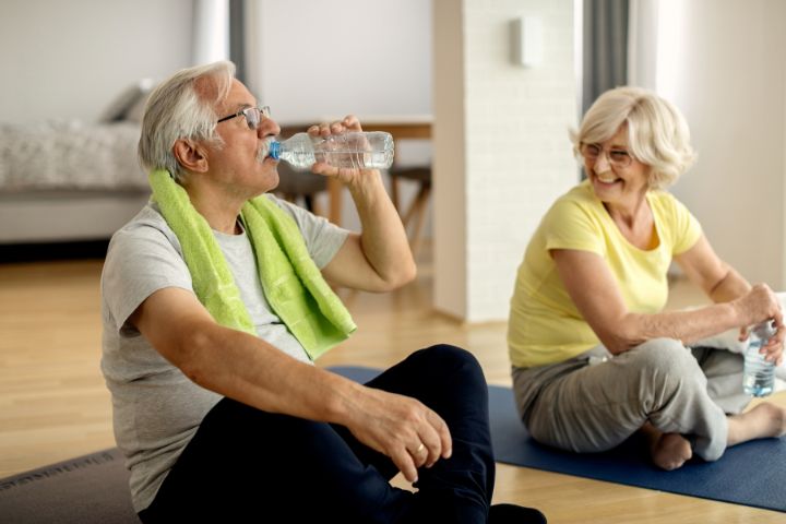 Older couple staying hydrated with water after exercise