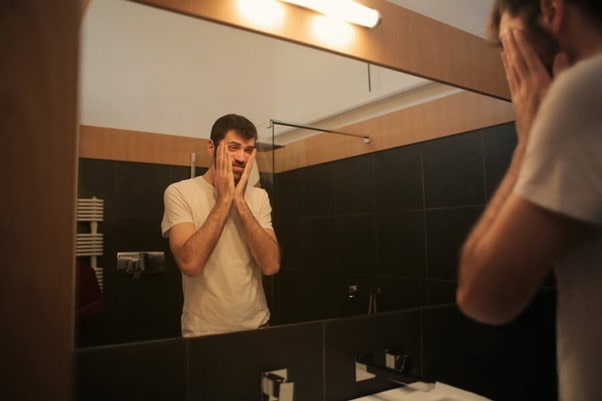 anxious man rubbing face
