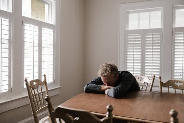 man sat at a table suffering from anxiety