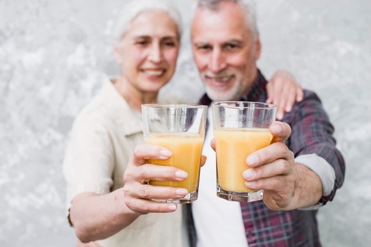 two elderly people holding drinks