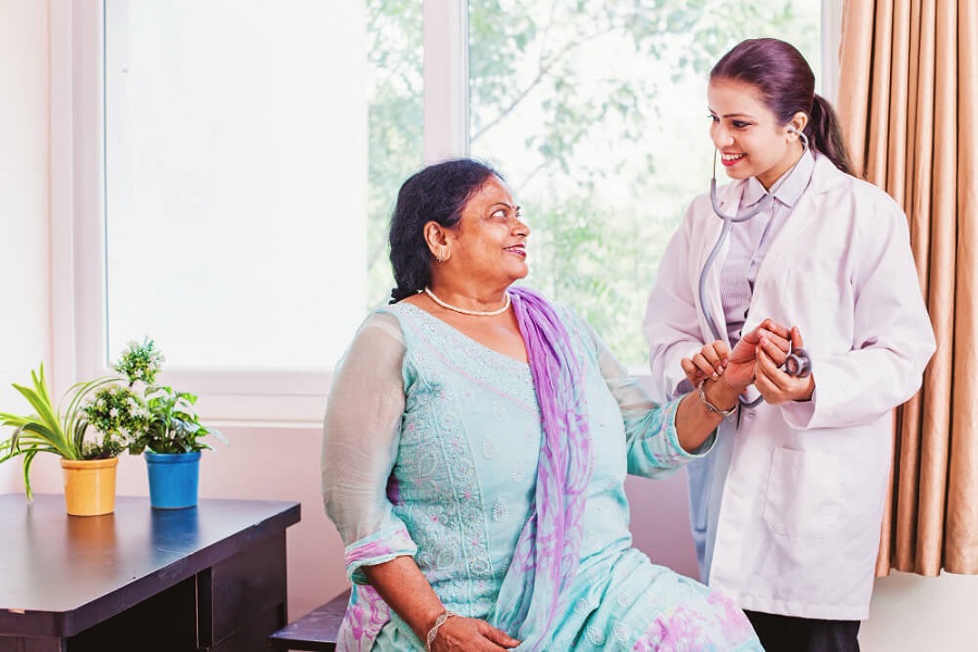 doctor helping elderly indian lady with incontinence associated dermatitis