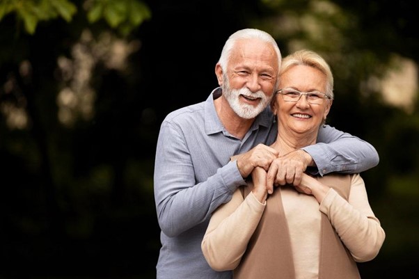 elderly man and women smiling looking at camera